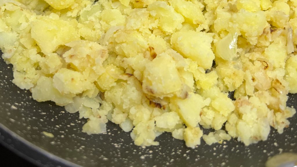 Desmigamos la patata cocida con la cebolla